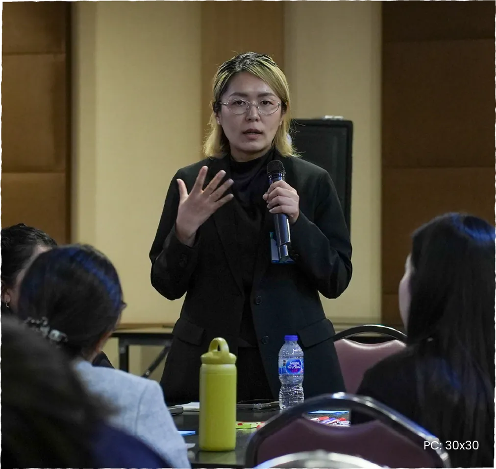 A participant speaking into a microphone during a coastal community workshop.