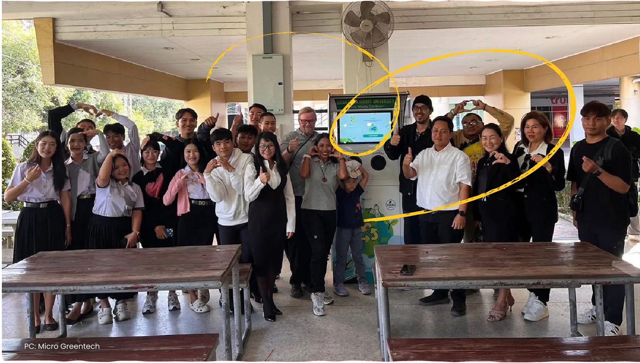 A group of partners and students posing together under an open pavilion.