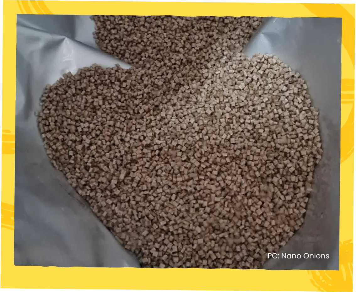 A heap of pale recycled plastic pellets arranged in the shape of a heart.