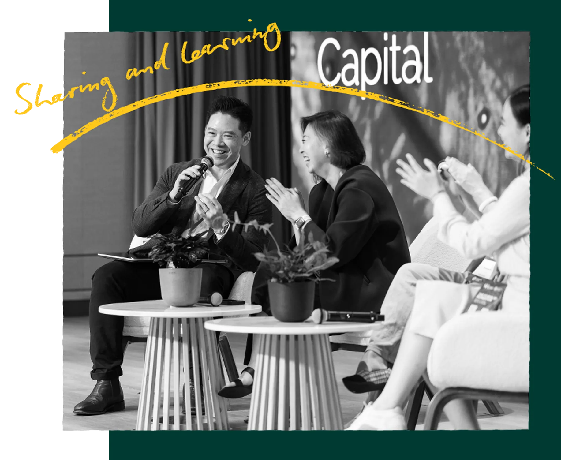 Panel speakers seated on stage, one holding a microphone mid-sentence while the others applaud. Handwritten caption: Sharing and learning.